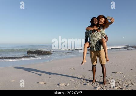 Happy couple taking a selfie on the beach Stock Photo