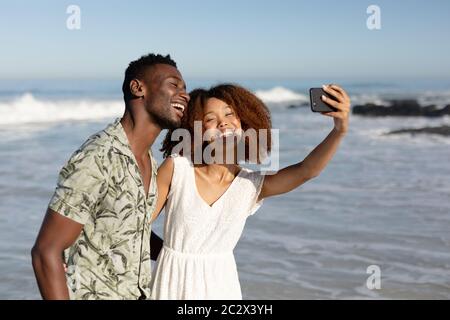 Happy couple taking a selfie on the beach Stock Photo