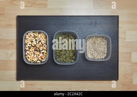 Cashews, pistachio, pumpkin seeds, sunflower seeds in plastic boxes Stock Photo