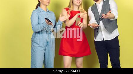 Group of friends using mobile smartphones. Teenagers addiction to new technology trends. Close up. Millenials texting, scrolling, chatting, watching video or shopping online. Connecting with devices. Stock Photo