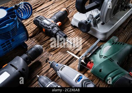 Various Power Tools Laying On Wooden Desk Stock Photo
