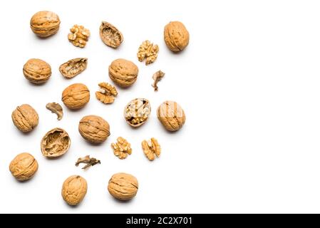 top view walnuts closed and broken scattered on a white background with copy space Stock Photo
