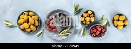 Olives flat lay panorama, top shot. Black, green and red olives of various sizes Stock Photo