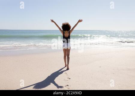 Mixed race woman standing on the beach Stock Photo