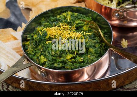 North Indian vegan spinach and lentil curry in traditional serving bowl Stock Photo