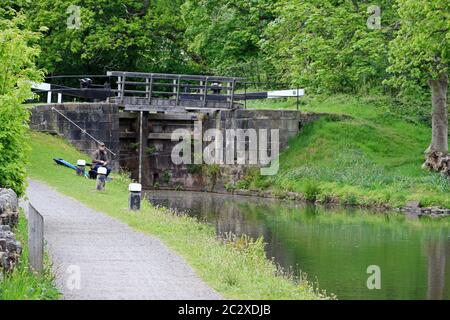 Angler fishing on banks of Rochdale canal Stock Photo