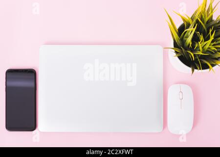 Top view of modern technology smart phone mobile and computer laptop close cover on pink background with copy space Stock Photo