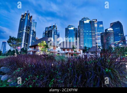 Cityscape in Mega Kuningan metropolitan building with some of white house and purple flower Stock Photo