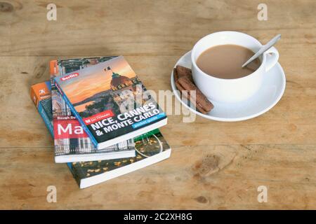 Travel books with cup of tea in white teacup on wooden table Stock Photo