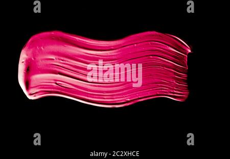 Pink lipstick brush stroke texture isolated on black background Stock Photo