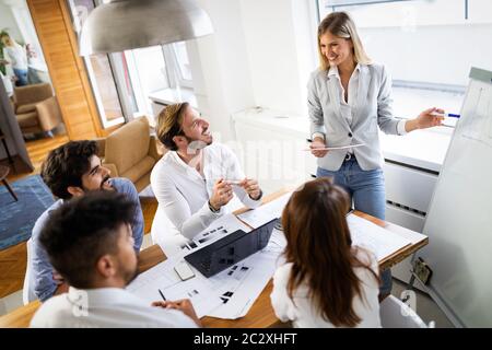 Team of architects working on construction plans in office Stock Photo