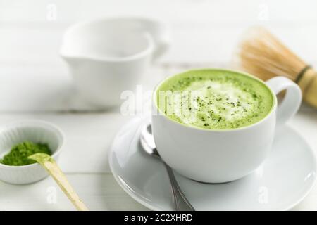 Green tea matcha latte cup on white background. This latte is a delicious way to enjoy the energy boost & healthy benefits of matcha. Stock Photo