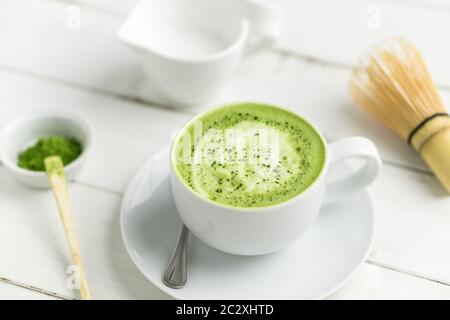 Green tea matcha latte cup on white background. This latte is a delicious way to enjoy the energy boost & healthy benefits of matcha. Stock Photo