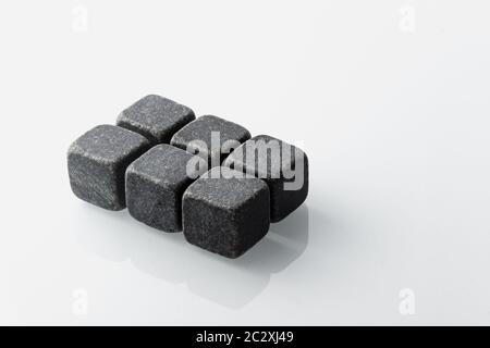 Set of six spirit chilling stones. Soapstone rocks are carved in cubes to be used as drink chiller (whisky, bourbon ...) Various type of raw minerals Stock Photo