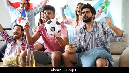 Excited fans of soccer friends celebrating winning match Stock Photo