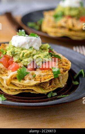 Stacked tostada dish closeup. Tostadas are a type mexican food, made with crispy fried corn tortillas covered with layers of various ingredients. Stock Photo