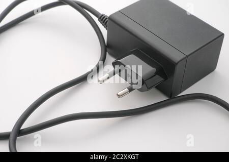 An AC adapter with some dust on it laying on a table. Close up. Stock Photo