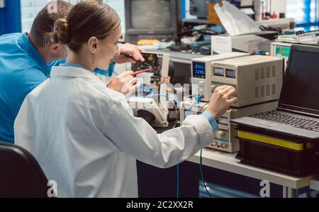 Two electronic engineers on the lab test bench measuring a new product for EMC compliance Stock Photo