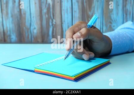 man's hand writing with pen on notepad  Stock Photo