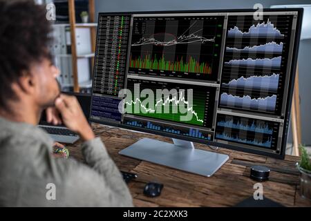 Young Businessman Working With Graphs At Desk Stock Photo