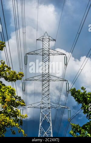 Tall electricity pylon with overhead high-tension power lines. Stock Photo