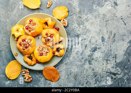 Ripe quince baked with nuts and raisins.Autumn dessert.Baked apples Stock Photo