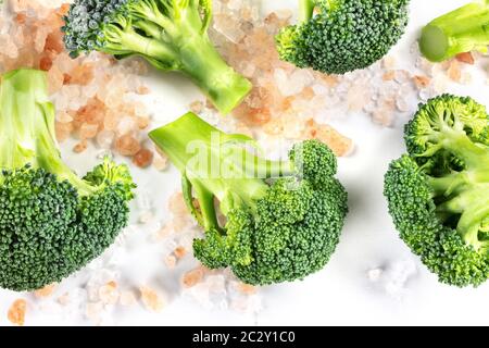 Broccoli florets close-up, shot from the top on a white background with salt Stock Photo