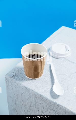 reusable cup with coffee on white table with white plastic cap and spo Stock Photo