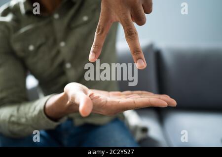 Man Using Sign Language To Communicate At Home Stock Photo