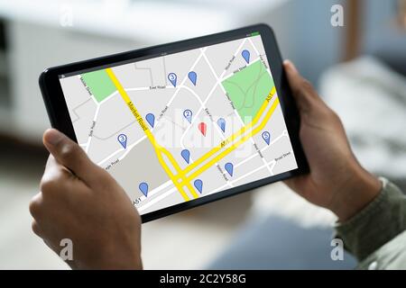 Close-up Of A Person Sitting In A Car Using GPS Service On Digital Tablet Stock Photo