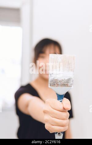 Woman holding a paint brush. Professional female painter Stock Photo