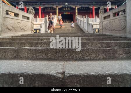 Unidentifiable people walking down the stairs leading to the Buddhist temple at the foot of Huashan mountain, Xian, Shaanxi Province, China Stock Photo