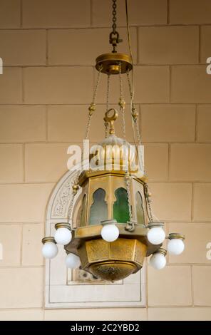 an old oriental lamp hangs from the ceiling of a building Stock Photo
