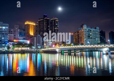 View of Taiwans modern and second largest city, Kaohsiung, at night. Lights of the Skyline and bridge reflecting in the water of the Love River Stock Photo