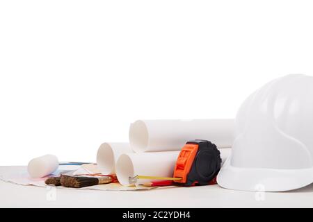 Architectural blueprints, construction hard hat, color palette guide, painting accessories on white background.  Architect workplace. Engineering tool Stock Photo