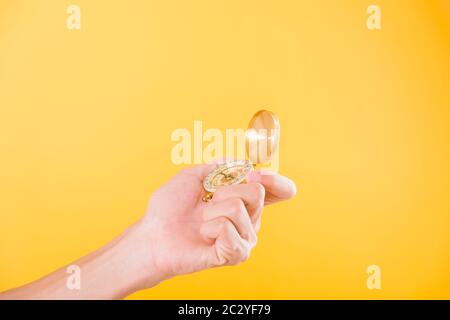 Hand holding antique brass compass isolated on yellow background with copy space for text Stock Photo