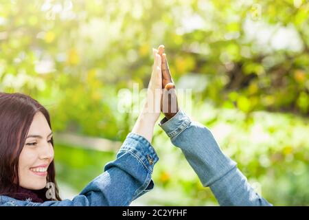 White Caucasian and black African American students holding hands together in world unity racial love and understanding concept. Stock Photo