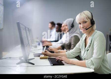 Positive Female Customer Services Agent With Headset Working In A Call Center Stock Photo