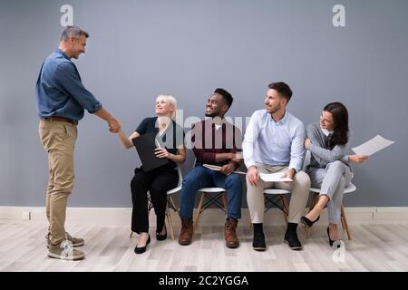 Smiling Young Businessman Shaking Hands With Female Candidate In Office Stock Photo