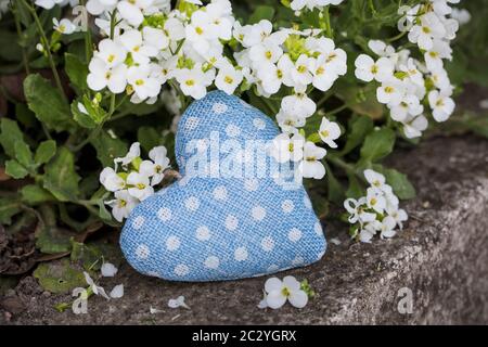 cute little fabric heart blue with white polka dots and tiny white garden flowers, perfect for a greeting card, gift bag or calendar Stock Photo