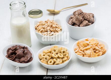 Various conrflake cereals in bowls and milk. Stock Photo
