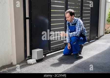 Repairman Fixing Broken Automatic Door In Building Stock Photo