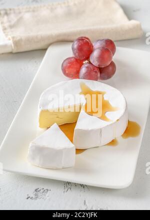 Camembert with bunch of grapes on the serving plate Stock Photo