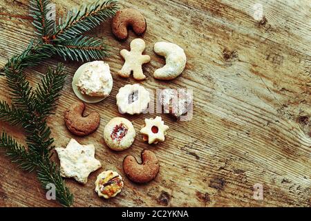 Delicious Christmas cookies and fir branches on a wooden background Stock Photo