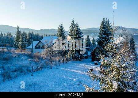 Houses covered with snow in a fantastic winter landscape from Ortoaia, Dorna Arini, Suceava County, Romania Stock Photo