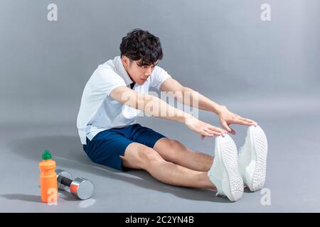 young man runner doing stretching exercise Stock Photo