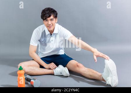 young man runner doing stretching exercise Stock Photo