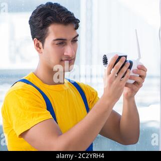 Contractor installing surveillance CCTV cameras in office Stock Photo
