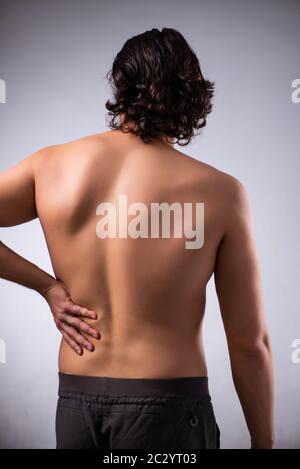 Man suffering from backbain on gray Stock Photo