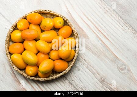 Pile of kumquat fruits, chinese tangerines, on wooden table. Stock Photo